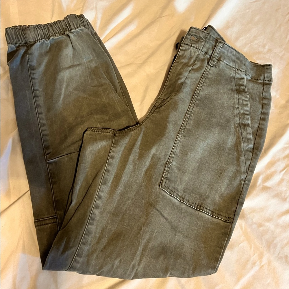 Army green pants with elastic on the bottom of the legs.